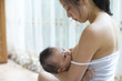 © Bonaoke/Stocksy - Young asian mother breastfeeding her baby boy in home