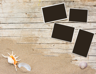 Sand and photographs on planked wood. Summer background with copy space. Top view