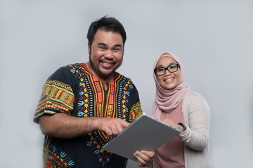 a chinese man and a malay woman using a tablet