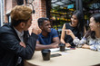 © Kencana Studio - a group of multi culture friends discussing work at cafe