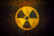 Round Yellow Radioactive (ionizing Radiation) Danger Symbol Painted On A Massive Rusty Metal Wall With Dark Rustic Grungy Texture Background With Vignetting.