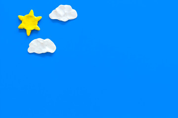 Wall Mural - clear and cloudly weather icons on blue background top view copy space