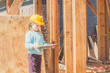 © dmitrypk - child in a helmet on the construction site of a wooden house