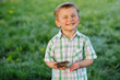 © Iryna - Cute blond little boy with defferent emotions holding little frog at summer day over green background.