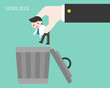 Big business hand throwing small businessman to trash bin, useless person concept