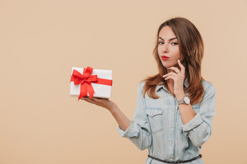 Poster - Portrait of a pensive young girl holding present box