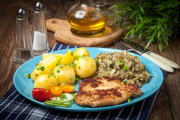 Wall Mural - Fried pork chop, baked potatoes and fried young cabbage.