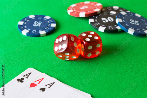 фотография Dice, poker chips and playing cards on the green table