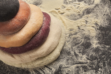 Wall Mural - Colorful fresh pasta dough on black table