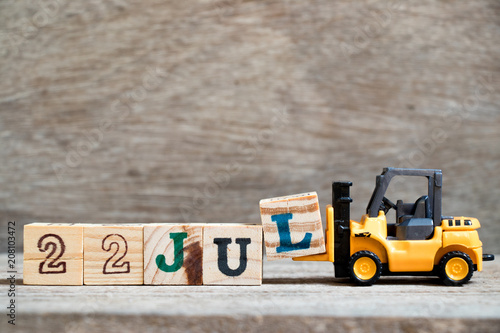 Poster Toy forklift hold block l to complete word 22 jul on wood background (Concept fo
