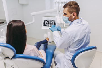 Wall Mural - patient consulting with dentist looking at x-ray