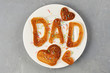 Special Father's Day breakfast. Alphabet Pancakes with sprinkles on white round plate. Top view, close up