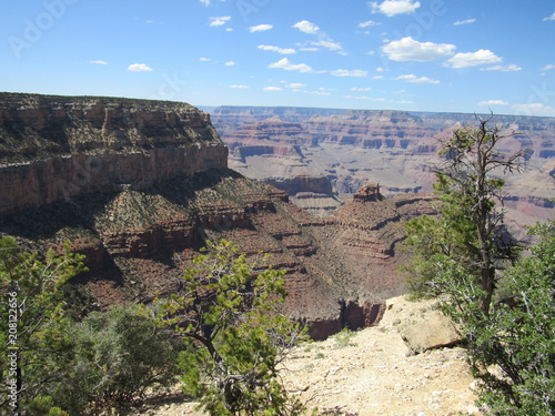 Fotografija  Grand Canyon National Park on a sunny day with blue sky and some clouds, as seen