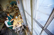 © pressmaster - Two women standing near workbench and working with wood in carpenter workshop.