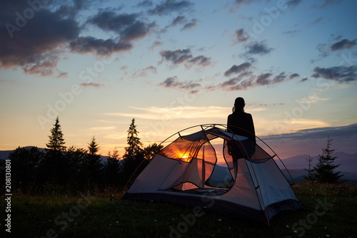 Fotografía Rear view silhouette of girl enjoy the dawn near the camping on top of mountain