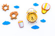 Put baby to bed concept. Childrens toys and clacks, baby accessories, alarm clock, clouds on white background top view
