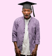 Poster - Young african graduate student black man scared in shock, expressing panic and fear