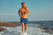 © djile - Handsome young man having fun on the beach by the sea