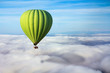 A lonely green hot air balloon floats above the clouds. Concept leader, success, loneliness, victory
