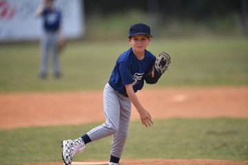 Young boy pitching the ball in a baseball game