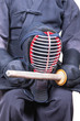 swordsman wear protective equipment 'bogu' and bamboo sword 'sinai'  for Japanese fencing Kendo training seat down