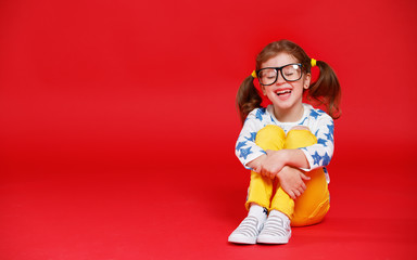 Wall Mural - funny child girl in glasses on colored background