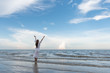 © May Chanikran - Happy young woman raised hands up on the beach with happily on blue sky and sea, time to traveling concept.