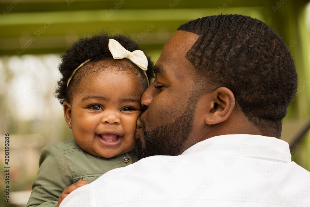 African American father holding his daughter. Stock Photo | Adobe Stock