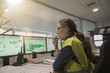 © goodluz - Woman in industrial control room using radio to give instructions