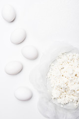 Wall Mural - top view of cottage cheese and eggs on white surface