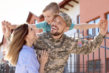 Wall Mural - Male soldier reunited with his family outdoors. Military service