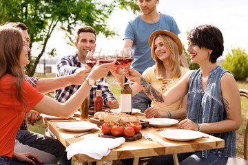 Poster - Young people with glasses of wine at table outdoors. Summer barbecue