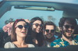 Having fun together. Portrait of happy four friends are traveling by car outdoor. They are looking forward and joy and laughing 
