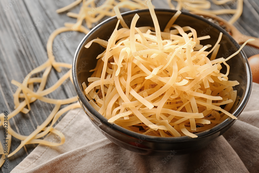 Bowl with uncooked pasta on table