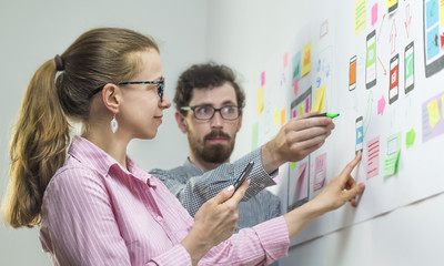 Wall Mural - two creative web designers are developing mobile applications in the workplace.