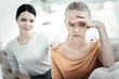 © Viacheslav Yakobchuk - Without understanding. Appealing female psychologist calming down unhappy teen girl who touching forehead and looking down