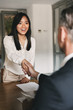 Business, career and placement concept - happy asian woman handshaking with male head director or employer of big company, after successful negotiations or interview