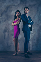 Wall Mural - Opposites attract! Full size fullbody vertical portrait of attractive, confident couple with crossed arms looking at camera pretty slim lady purple tight dress gentlemen in tux standing over grey wall