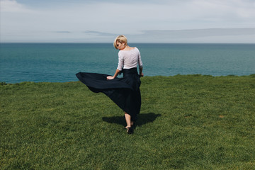 Wall Mural - stylish beautiful girl posing on majestic cliff, Etretat, Normandy, France