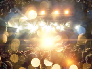 Wall Mural - interior view of a concert hall crowded with fans in front of a bright stage