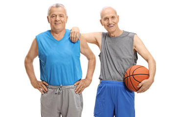 Wall Mural - Two mature men in sportswear with one of them holding a basketball