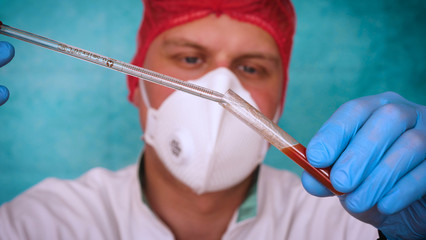 The alchemist, a biologist, takes the DNA of various substances, in a respirator, in a protective cap, in goggles, in a white medical gown, a flask, a green background, a science table.