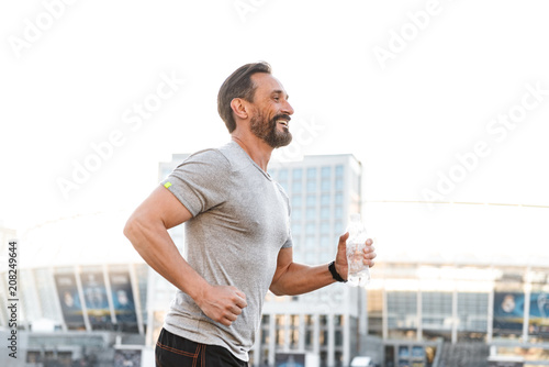 Fotografia Handsome strong mature sportsman running