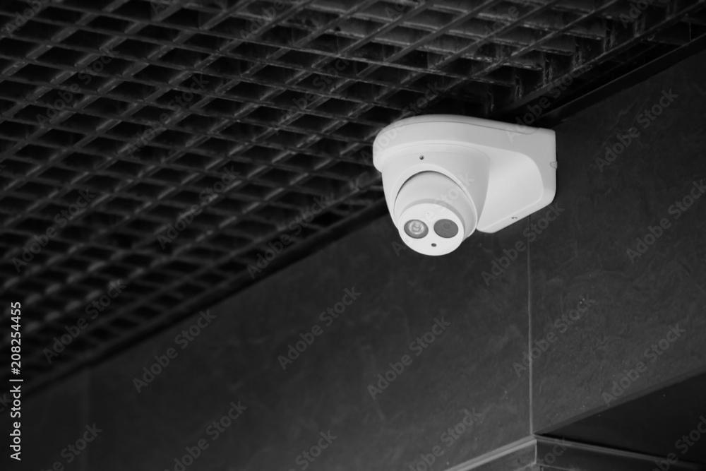 Modern CCTV camera on wall of building outdoors