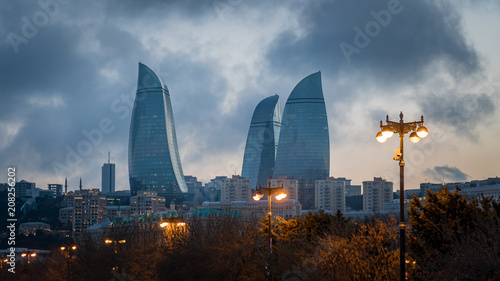Fotomural Baku evening cityscape with flaming towers and reflections in the Caspian sea ba
