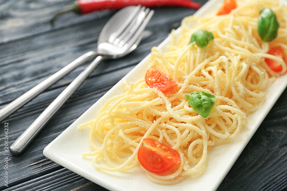 Plate with spaghetti and tomatoes on table. Delicious pasta recipes