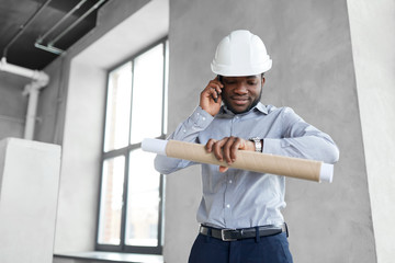 Wall Mural - architecture, construction business and people concept - african american architect in helmet with blueprint calling on smartphone and looking at his wristwatch