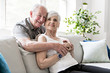 © Louis-Photo - Affectionate attractive elderly couple sitting together on a couch