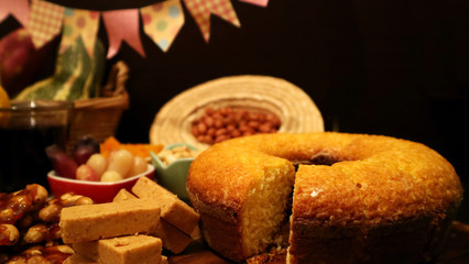 Wall Mural - Festa Junina traditional food on dark background. Seletive focus on cake. Copy space for text. Brazilian June Feast.