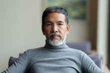 Portrait Of Attractive Mature Asian Man Retired With White Stylish Short Beard Sitting On Couch At Coffee Shop Cafe. Close Up Of Old Handsome Businessman Or Entrepreneur In Urban Lifestyle Concept.